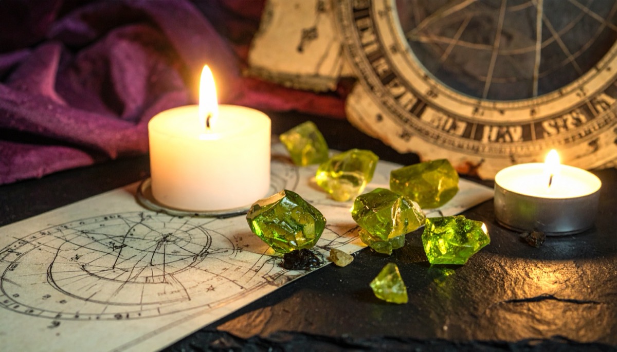 bright yellow green rough chunks between two lit candles on an old astrological chart