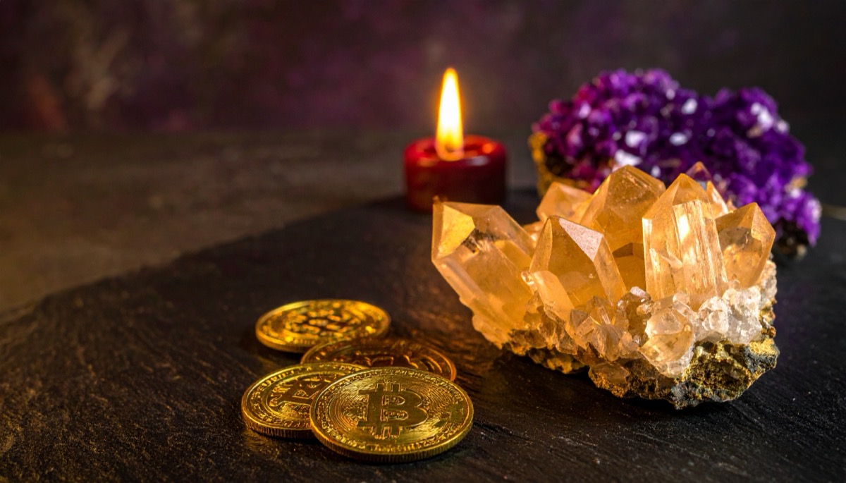 a golden crystal cluster and stacked gold coins beside a purple cluster and red candle