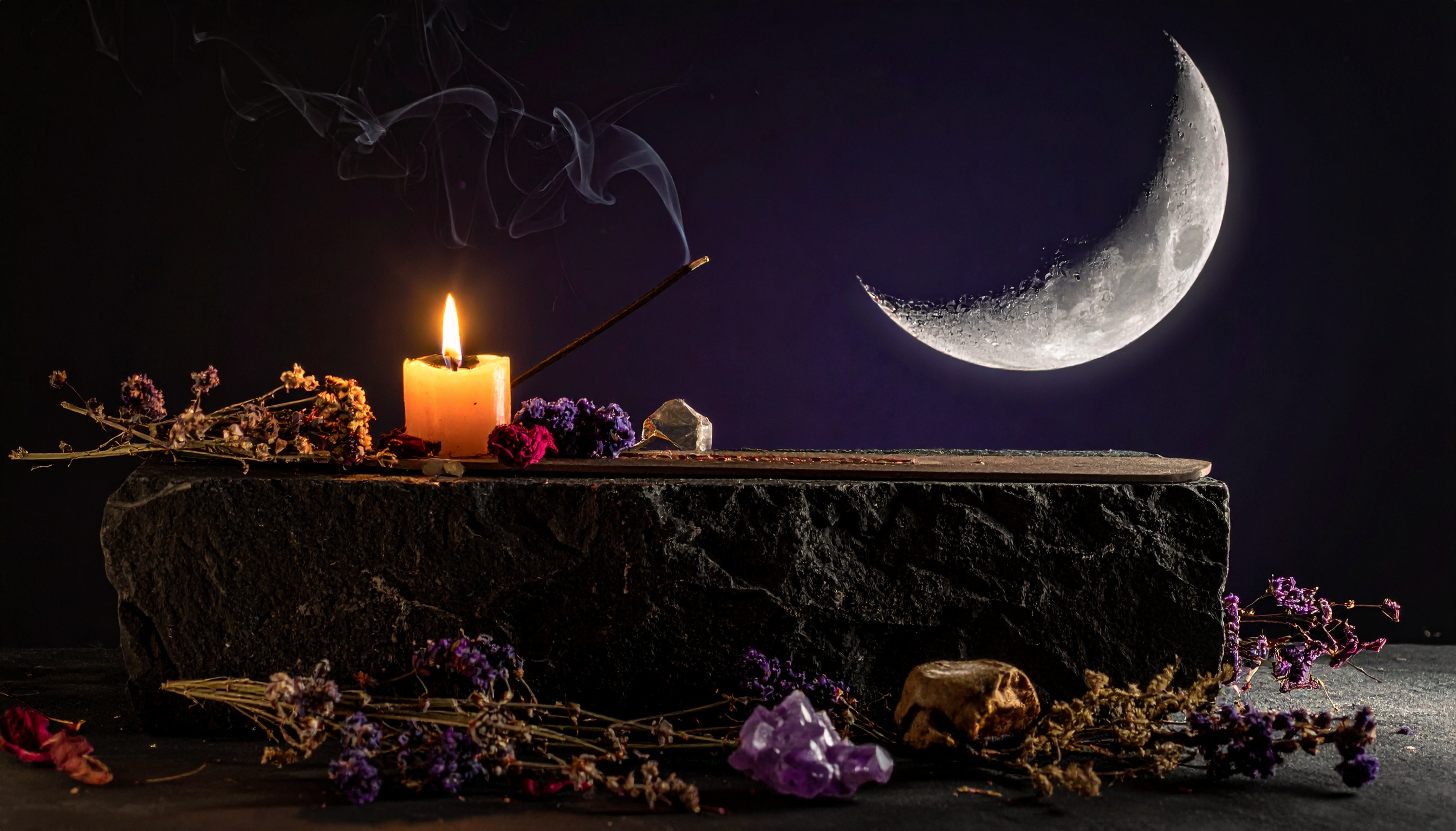 Moon ritual crystals and a candle in low candlelight, manifestation theme